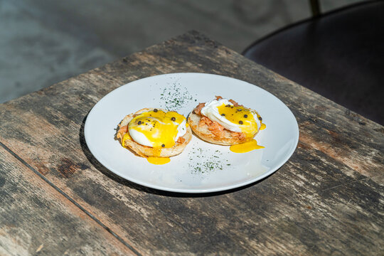 Egg benedict or poached egg with salmon on white plate. Isolated by wooden background or table. Food photography