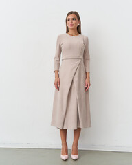 Elegant woman modeling a fashion-forward dress in a contemporary studio setting
