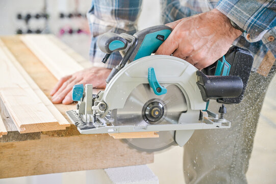 A skilled craftsman operates a circular saw on a wooden plank, showcasing precision and craftsmanship in a well-lit workshop environment, highlighting woodworking techniques