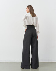 Elegant female model showcasing fashion in a studio with modern styling and poses