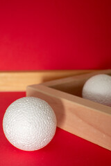 Still life with wooden blocks and a a plastic foam ball on red background	