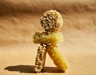 Creative food composition of ramen noodles over beige.