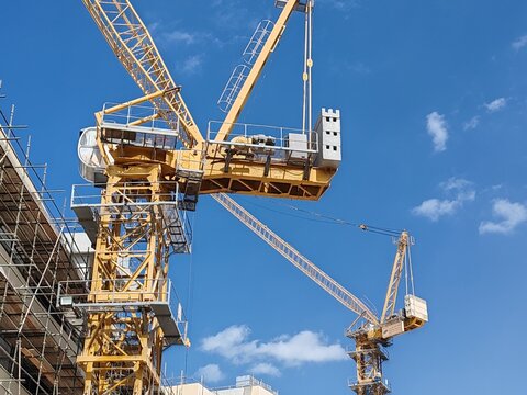 Yellow Color Fixed Crane Erected Beside Under Construction Residential Building.
Highrise Portable Remote Mobile Tower Crane Lifting Heavy building Material from ground to top level construction site.