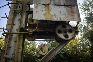 A rusted old machine with a chain and gears
