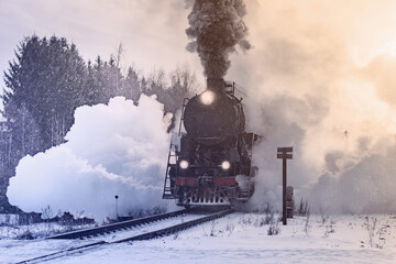 Retro steam train departs at winter morning.