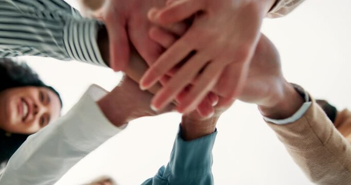Business people, meeting and hands together with motivation below for collaboration or mission on a white background. Low angle or closeup of young employees touching in teamwork, unity or solidarity