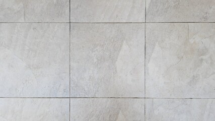 Gray tile floor outside of a building in the city. Texture image. The old walkway has stains.