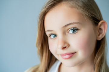 Fototapeta premium Portrait of a beautiful blue-eyed girl of 9 years old on a white background. Happy child.
