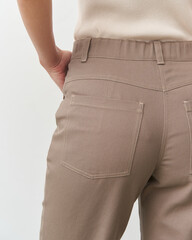 Studio model showcasing stylish beige pants with a chic and modern look