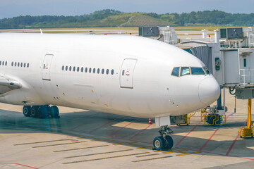 View of the front nose fuselage landing gear and cockpit straight ahead and the docking gangway air bridge.