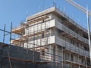 Under construction residential building with Concreate Block structure and Fixed Tower Crane.
Exterior viewHighrise Multistory building modern design,
Yellow Fixed Tower Crane and erected Scaffolding.