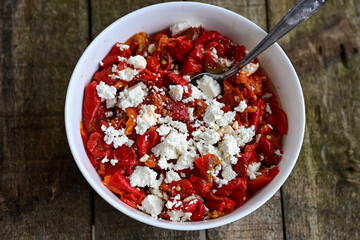 Traditional Bulgarian shopska salad with  tomatoes ,cucumbers and cheese on wooden board