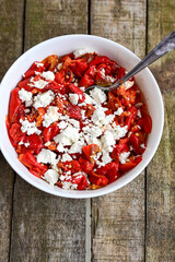 Traditional Bulgarian shopska salad with  tomatoes ,cucumbers and cheese on wooden board