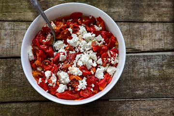 Traditional Bulgarian shopska salad with  tomatoes ,cucumbers and cheese on wooden board