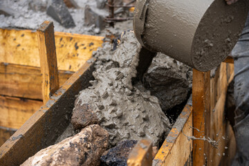 Manual pouring of concrete into the foundation
