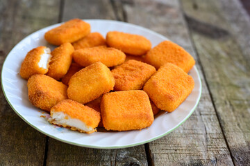 White cheese nuggets on wooden background. Vegetarian  cheese  breaded oven baked  snack