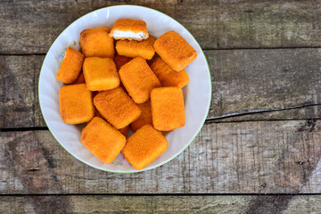 White cheese nuggets on wooden background. Vegetarian  cheese  breaded oven baked  snack