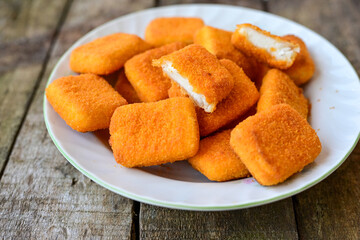White cheese nuggets on wooden background. Vegetarian  cheese  breaded oven baked  snack