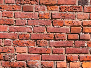 Part of a brick wall, red in color, of an old house