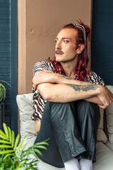 Young non-binary person relaxing on sofa at home embracing body positivity and gender identity