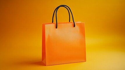 A blank orange shopping bag sits against a yellow backdrop.  Perfect for Halloween or fall sale ads.
