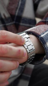 A businessman looks at his watch and checks the time.
A man is late for work and looks at his wristwatch.
A stylish mechanical watch on the hands of a businessman