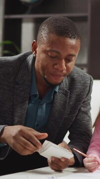 Black English teacher shows cards and tells letter names to little children studying foreign language during lesson with native speaker slow motion