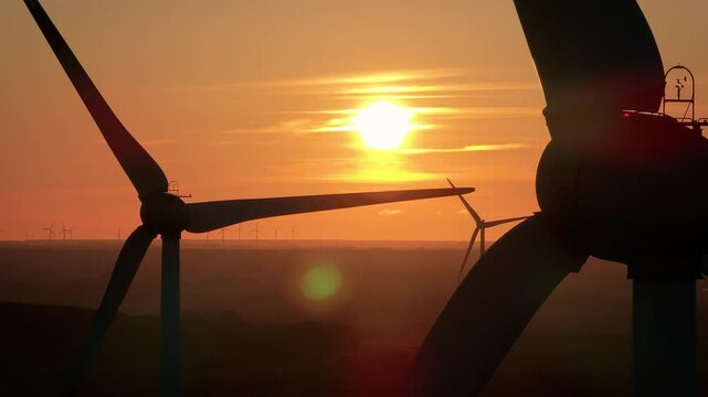 Wind farm at sunrise, wind generators aerial view, windmills generating electricity, drone shot, golden hour, green renewable energy, wind turbine