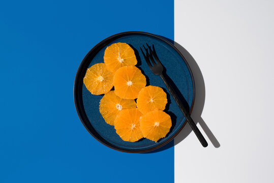 Minimalist orange slice presentation in a blue and white background