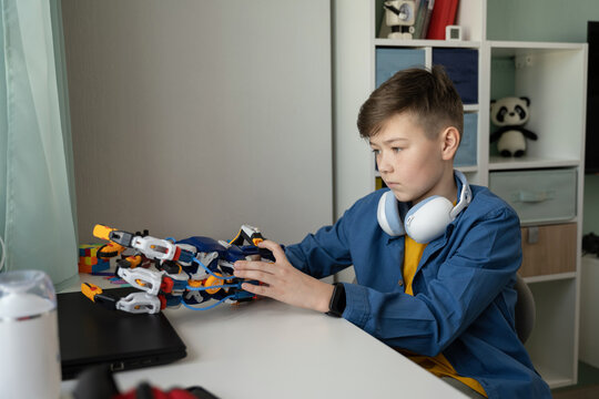 Young Innovator Engaged in Robotics at Home Desk