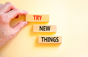 Try new things symbol. Concept words Try new things on beautiful wooden block. Businessman's hand....
