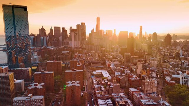 Beautiful golden light covers the scenery of Manhattan, New York. Sun shines from behind the skyscrapers downtown. Aerial perspective.