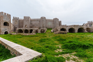 Historic Medieval Castle Ruins with Green Grass and Stone Archways..