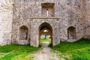 Historic Stone Gate Entrance of Ancient Fortress with Green Grass Surrounding..