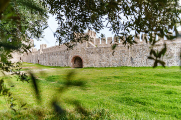 A restored historical stone fortress surrounded by lush green grass