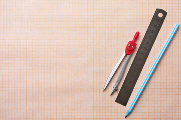 Concept of studying at school and back to school. Pens, pencils and ruler on school squared paper background, copy space