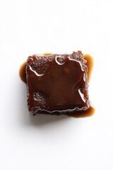 Moist square bite of rich chocolate cake with thick caramel sauce generously poured over the top

