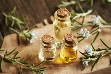 Three bottles of rosemary essential oil on a table