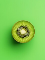 Close-up of a kiwi slice on a bright green background. the slice is cut in half, revealing the juicy, green flesh and small black seeds inside.