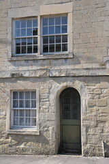 Exterior view of an old stone house on a street in an English city