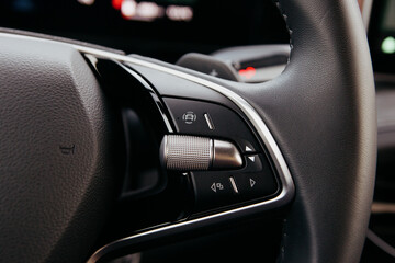 Obraz premium Close up of a modern car steering wheel showcasing controls and buttons highlighting driver interface and advanced technology