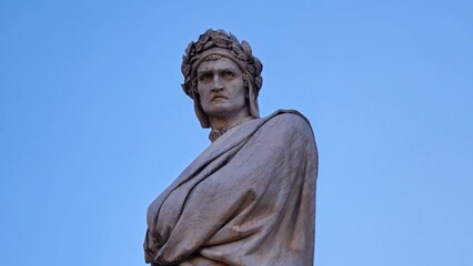 Florence, Italy - 4 January 2025. Marble statue of Dante Alighieri with laurel crown and draped...