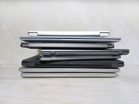 stack of laptops on a gray background, on the table, laptop computer, tablet, business, work, remote work, freelance.