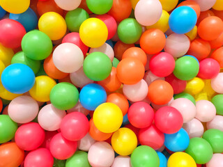 Lots of multi-colored plastic balls in a dry pool. Children's play area. Cheerful, rainbow mood. The concept of a holiday, joy and childhood.