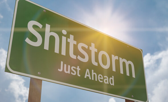 Shitstorm Just Ahead Green Road Sign Against a Blue Sky and Clouds.