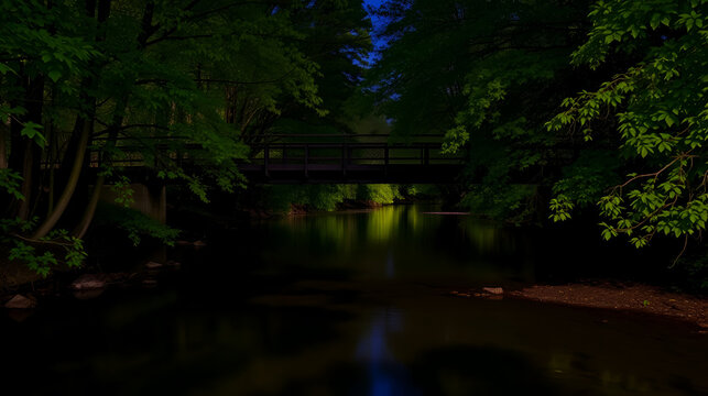 Calm Lynx Creek river flowing under the Foot Bridge alongside the green trees at night - Powered by Adobe