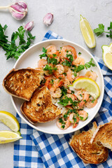 Lemon garlic butter srimp in a white frying pan.top view