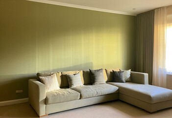 Fototapeta premium A living room with a sectional couch and a window.