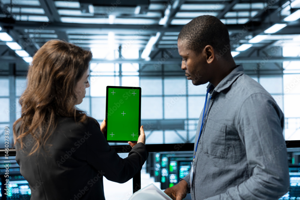Poster team of technician in data center using green screen mockup tablet, adjusting power management setti