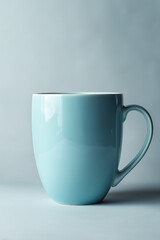 Obraz premium Blue ceramic mug against a soft gray background 